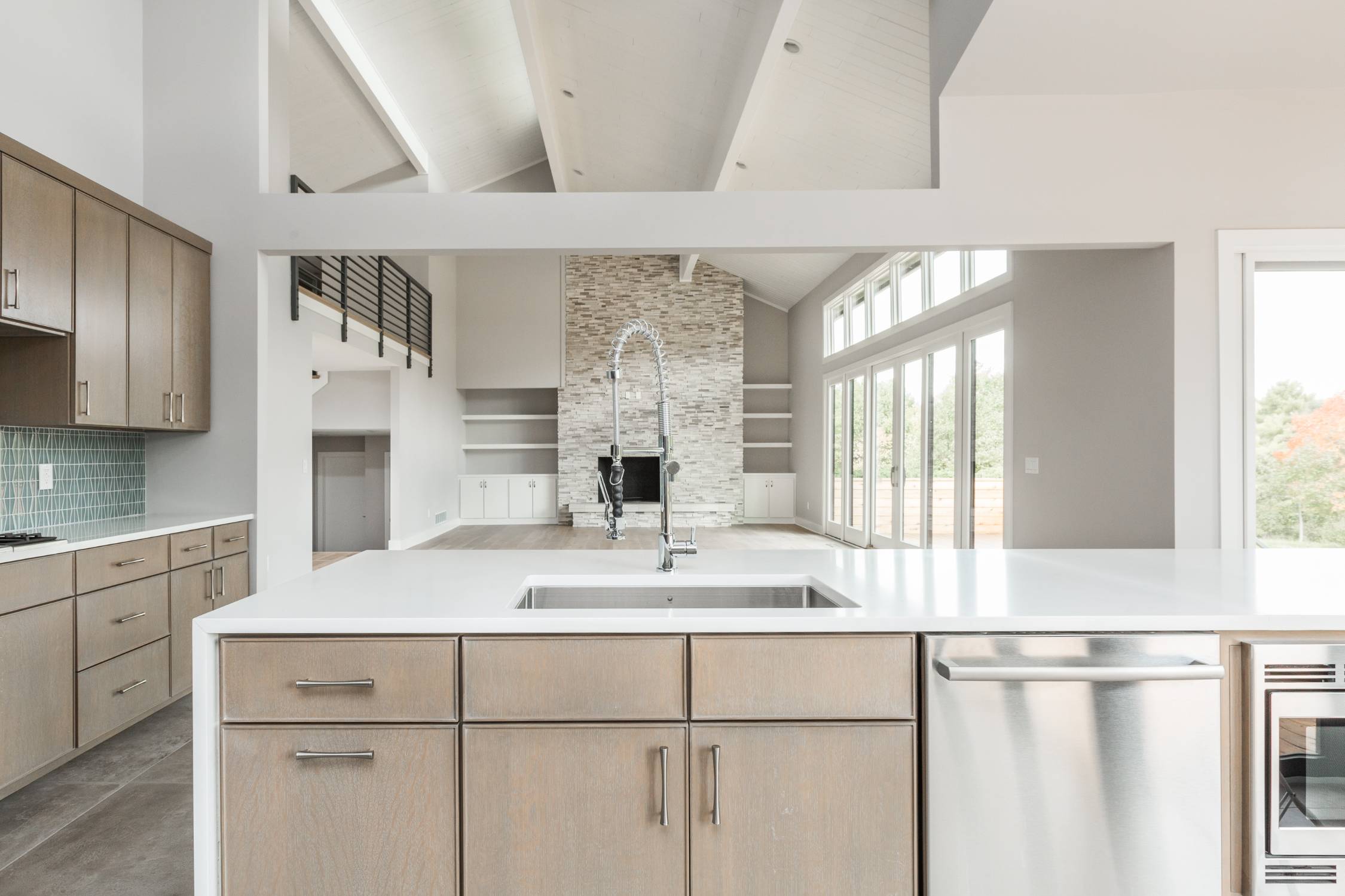 Open-concept custom home interior with vaulted ceilings, stone fireplace, and floor-to-ceiling windows by Eaton Custom Homes